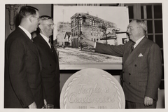 Reflecting on Early Days (Executive Seal Display) VP Raymond E. Olson (left) beside two colleagues at the 1851–1951 Centennial seal and factory portrait.