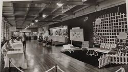 Centennial Exhibition Hall (Wide View) Overview of the Ames Street plant floor, including registration tables and product exhibits.